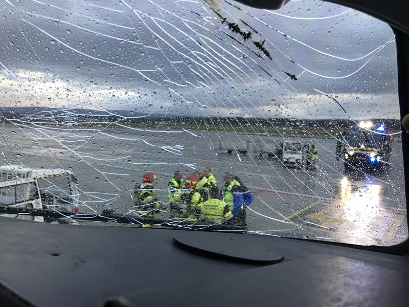 Blick durch eine gesprungene Cockpitscheibe auf die Feuerwehr am Boden
